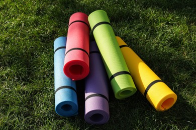 Photo of Bright exercise  mats on fresh green grass outdoors