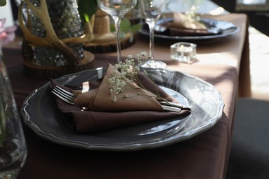 Festive table setting with beautiful tableware and floral decor indoors