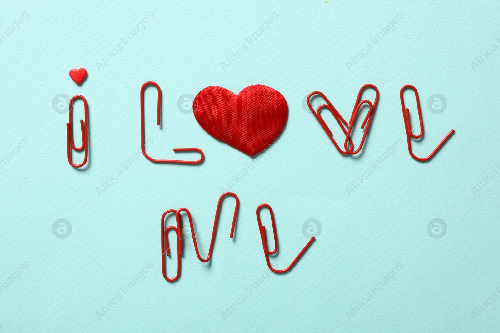 Photo of Phrase I Love Me made of clips and red hearts on turquoise background, flat lay