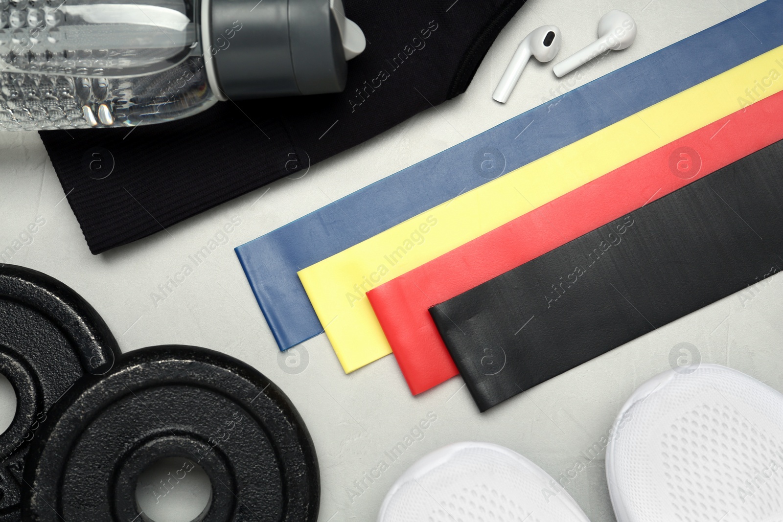 Photo of Flat lay composition with fitness elastic bands on light background