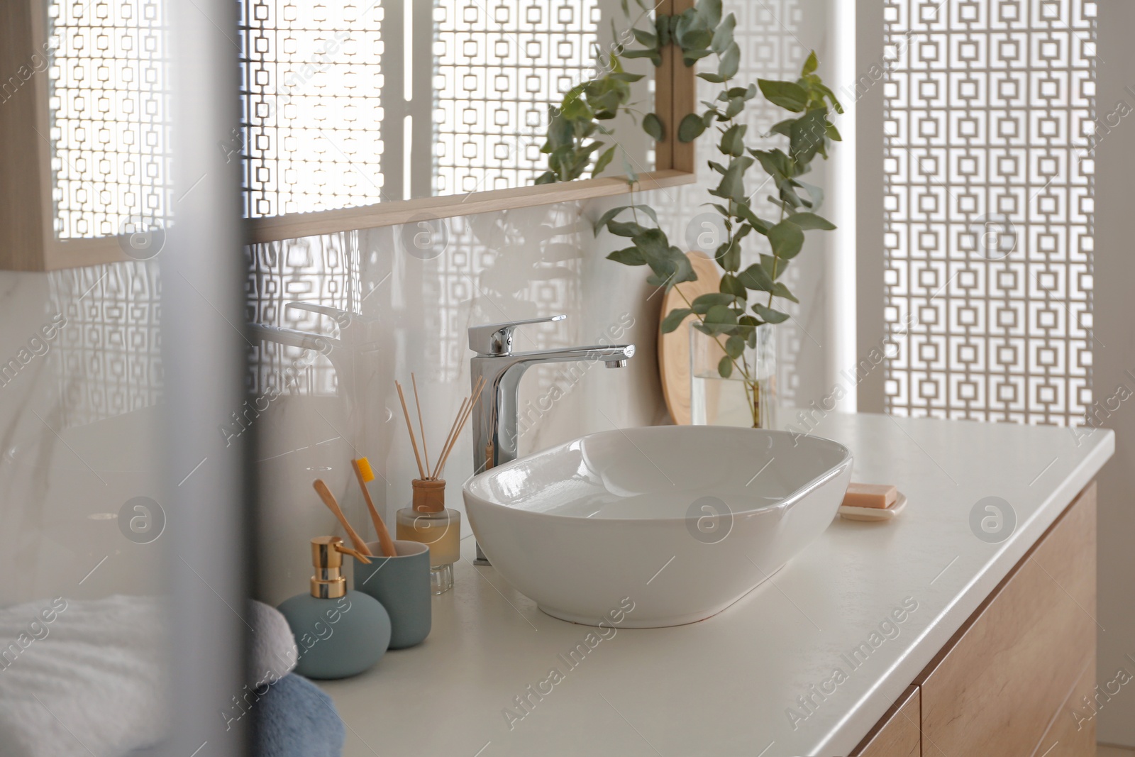 Photo of Stylish vessel sink under mirror in bathroom. Interior element