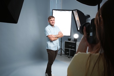 Photo of Handsome model posing for professional photographer in photo studio