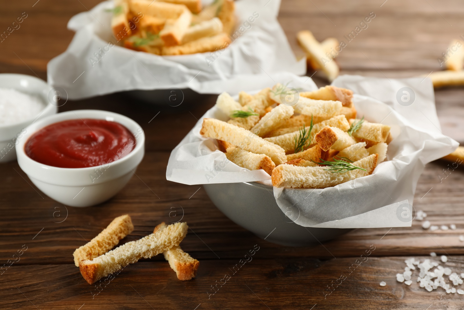 Photo of Delicious hard chucks with ketchup on wooden table