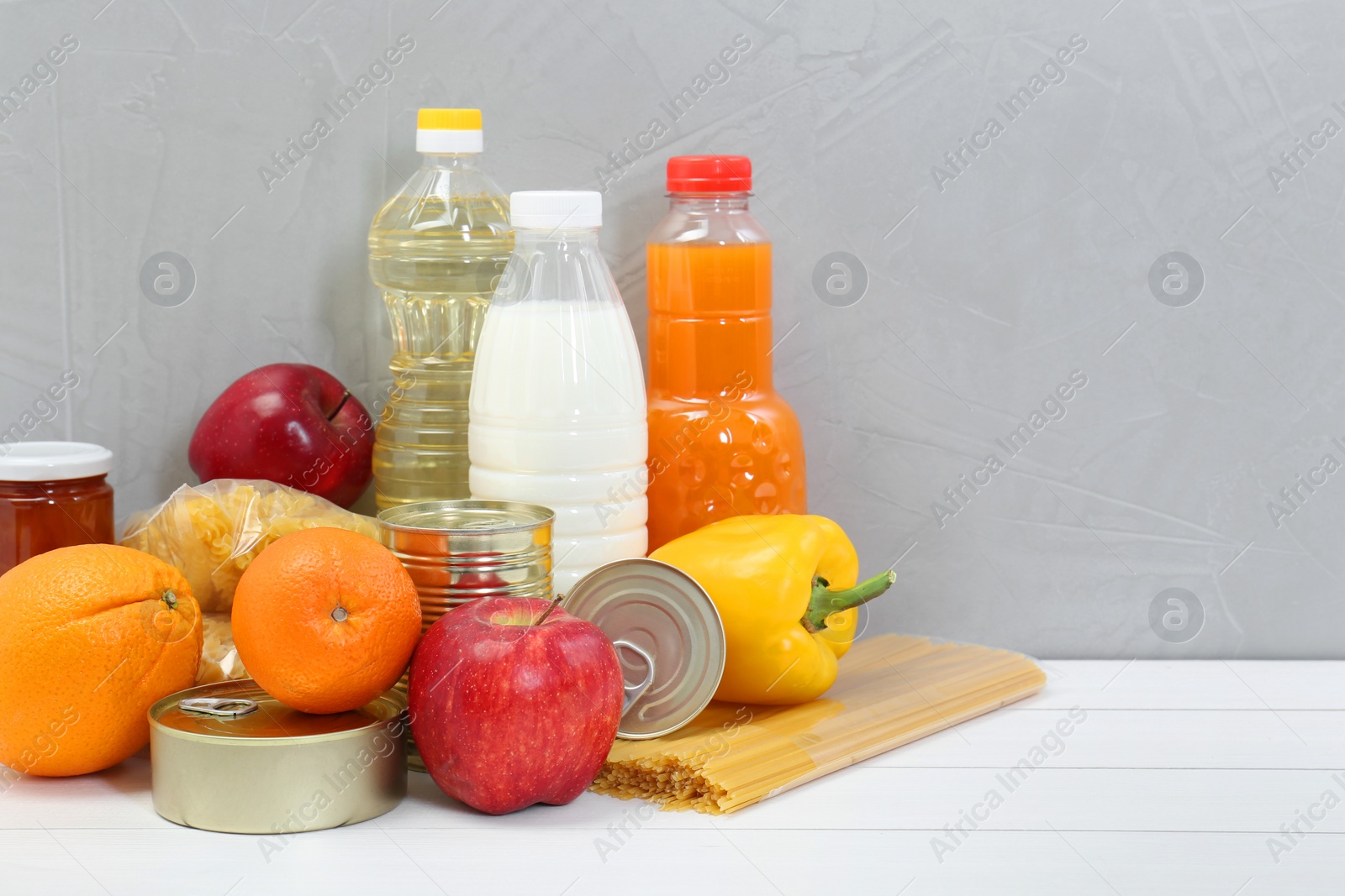 Photo of Humanitarian aid. Different food products for donation on white wooden table. Space for text