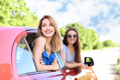 Happy beautiful young women together in car