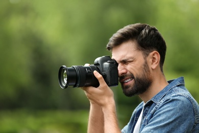 Photo of Photographer taking photo with professional camera in park