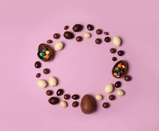 Photo of Flat lay composition with chocolate Easter eggs and space for text on color background