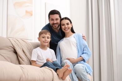 Photo of Portrait of happy pregnant woman with her son and husband at home