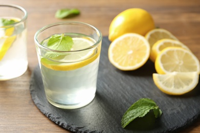 Photo of Glass with lemon water on slate plate