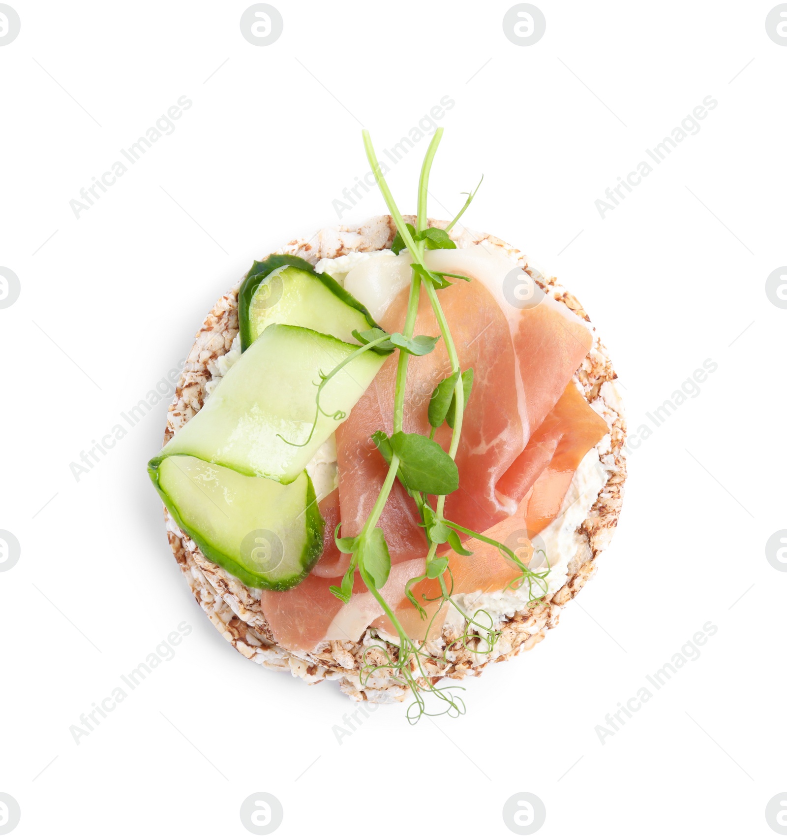 Photo of Crunchy buckwheat cakes with cream cheese, prosciutto and cucumber slice isolated on white, top view