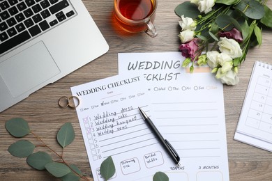 Photo of Flat lay composition with Wedding Checklists on wooden table