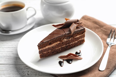 Plate with slice of homemade chocolate cake served on wooden table