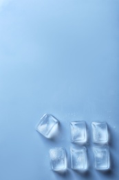 Ice cubes on color background, top view. Space for text