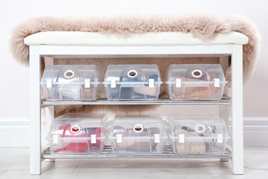 Photo of Plastic boxes with female shoes on rack near wall. Storage organization