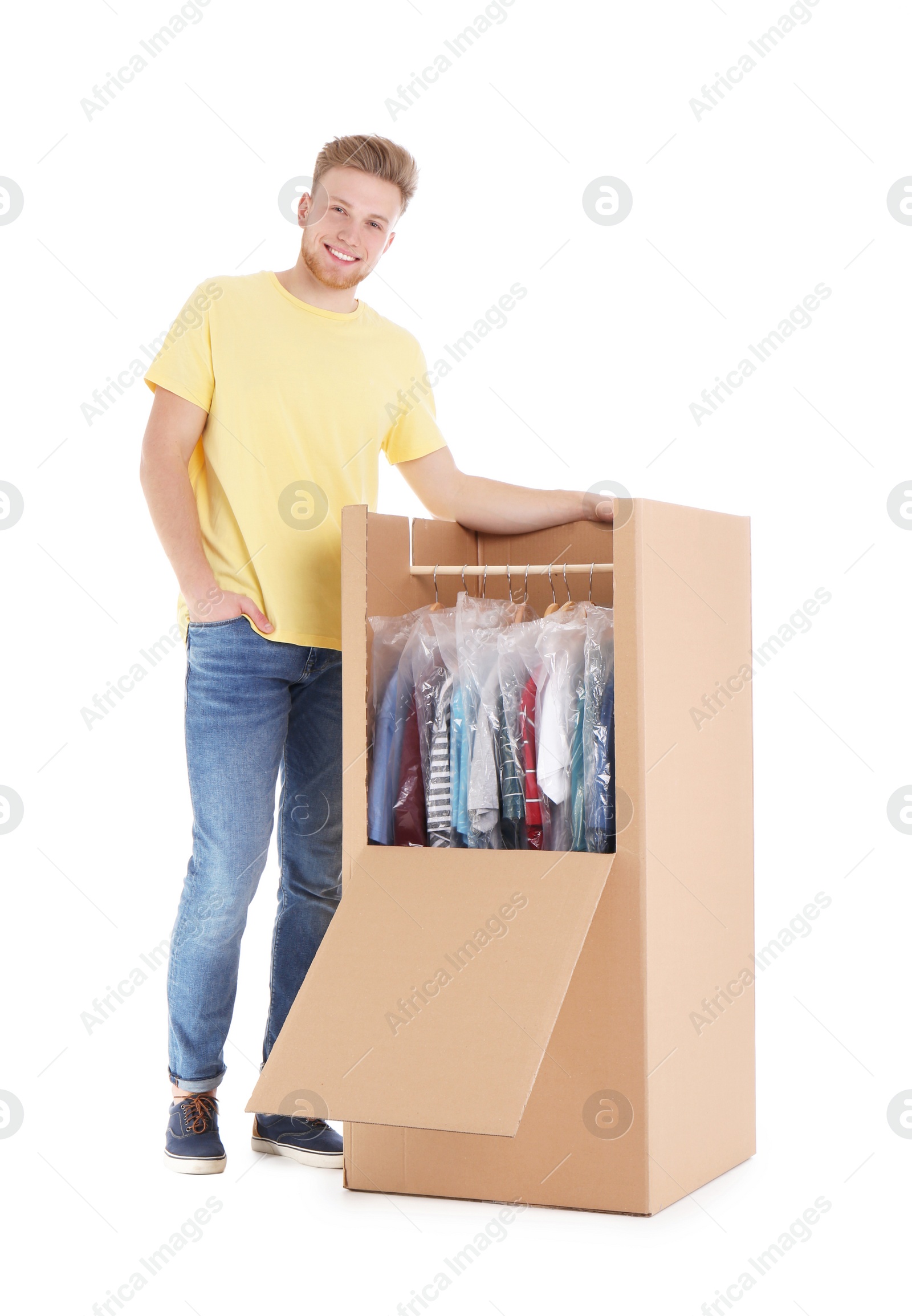 Photo of Young man near wardrobe box on white background