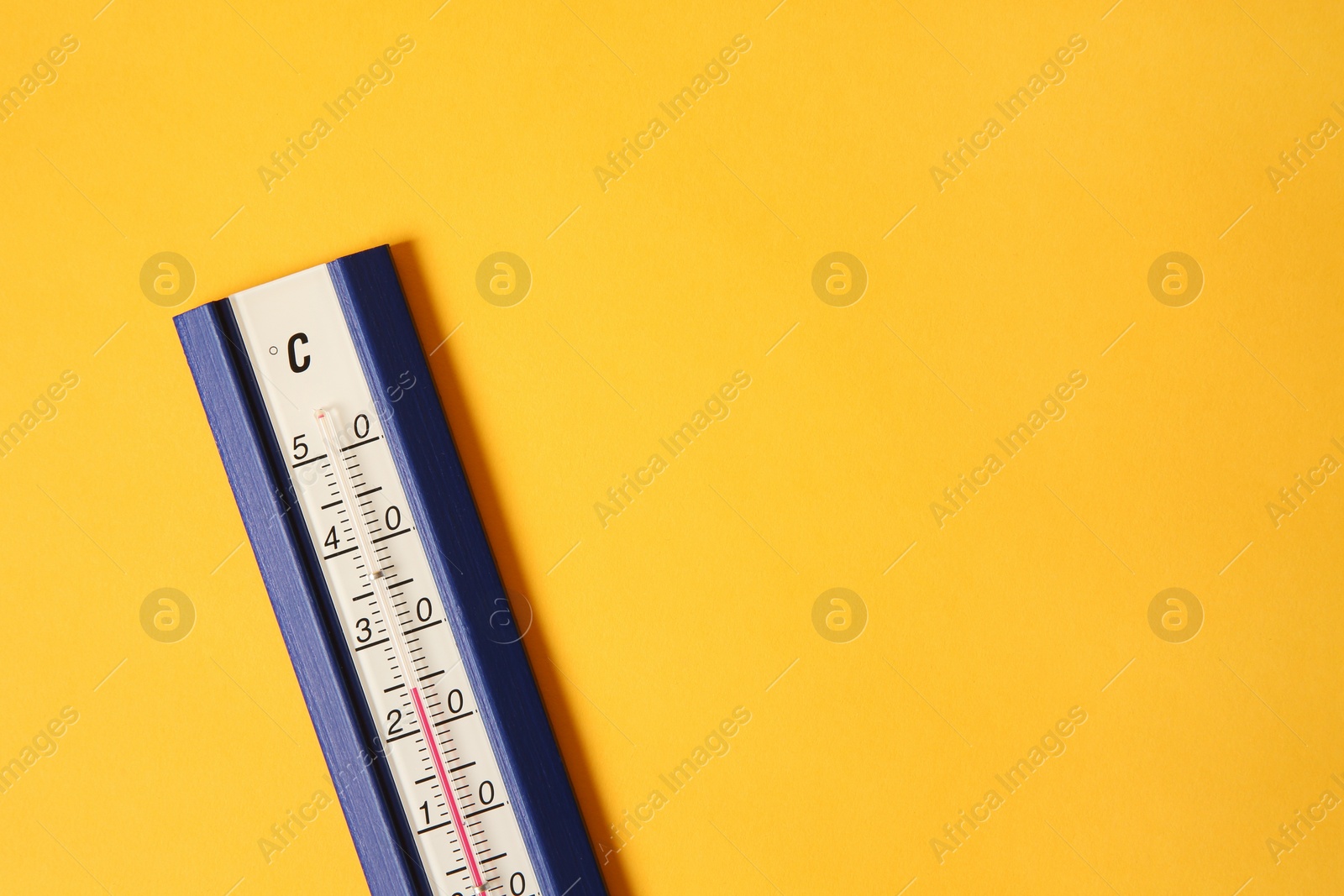 Photo of Weather thermometer on yellow background, top view. Space for text