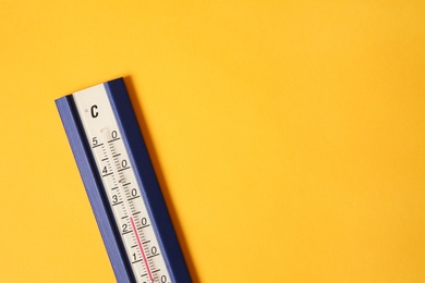 Weather thermometer on yellow background, top view. Space for text