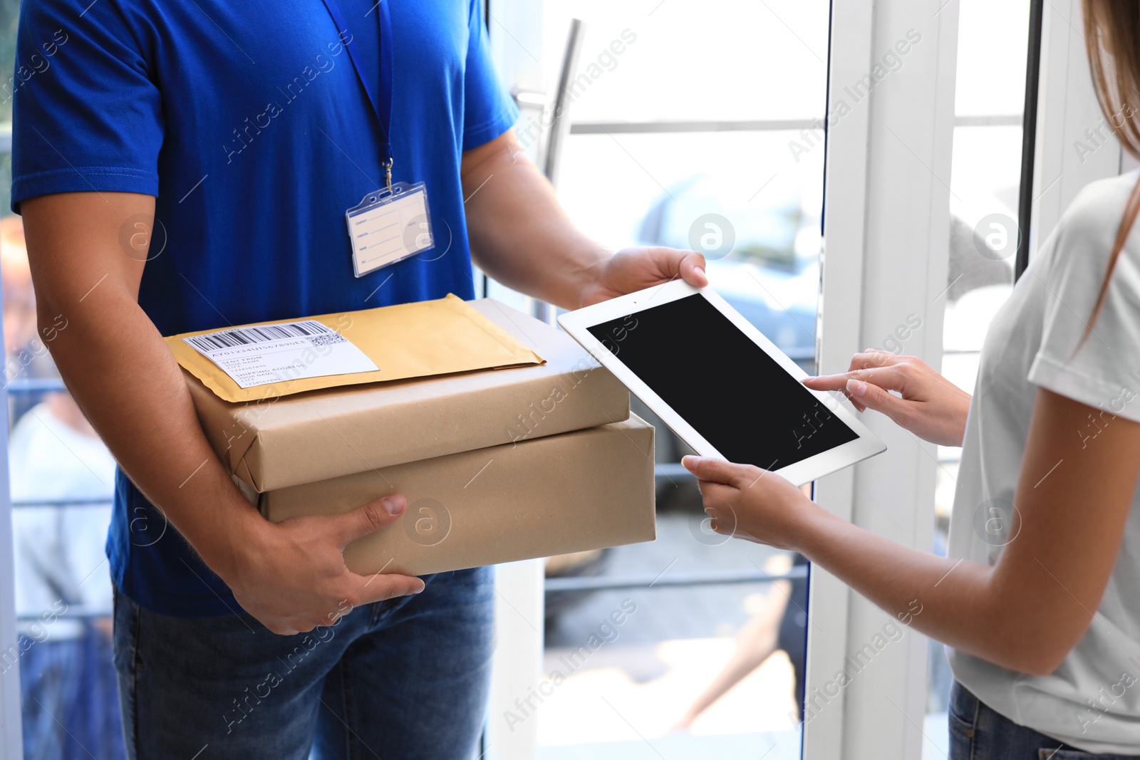 Photo of Woman using app to confirm delivery of parcels from courier on doorstep, closeup