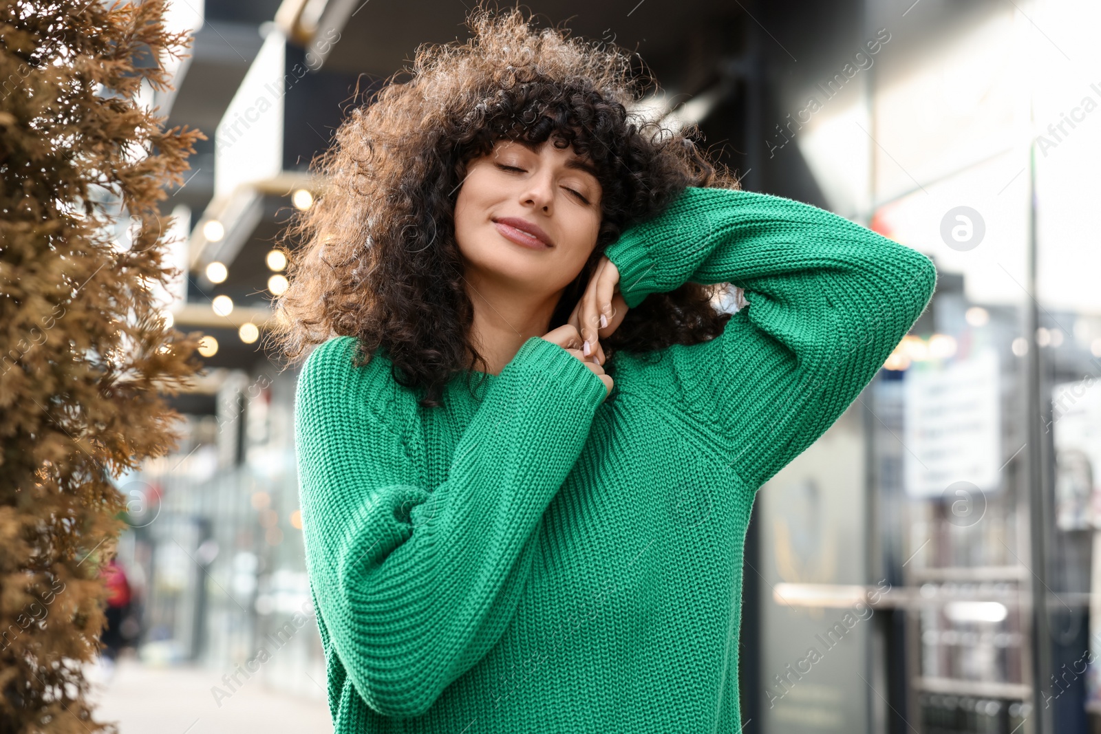 Photo of Young woman in stylish green sweater outdoors