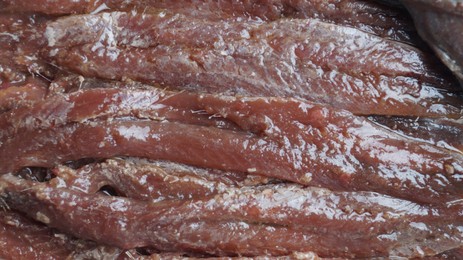 Photo of Canned anchovy fillets as background, closeup view