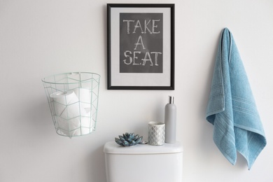 Photo of Decor elements, necessities and toilet bowl near white wall. Bathroom interior