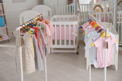 Photo of Baby clothes hanging on rack in store. Shopping concept