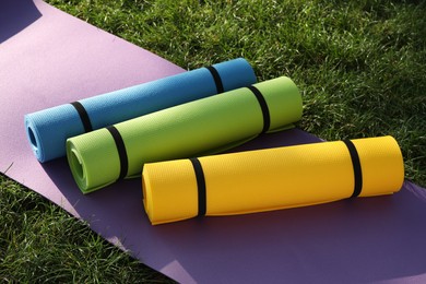 Bright exercise mats on fresh green grass outdoors