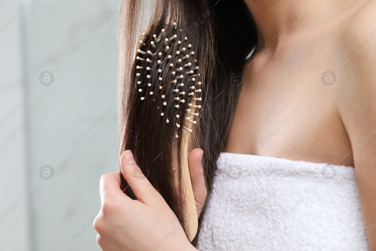 Photo of Young woman with hair brush in bathroom, closeup view