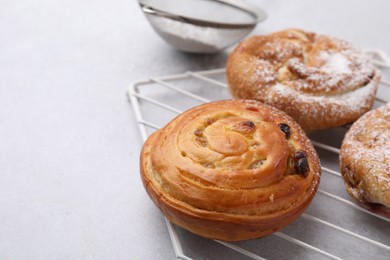 Different delicious rolls on light table, closeup and space for text. Sweet buns