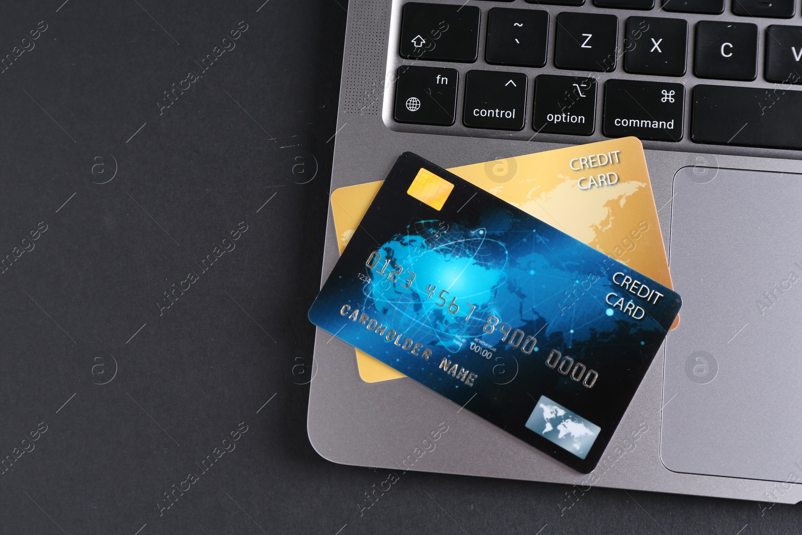 Photo of Credit cards and laptop on grey table, flat lay