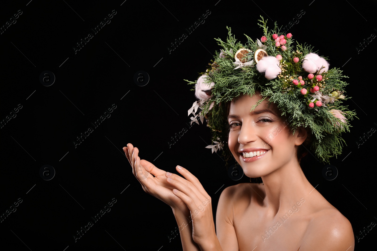 Photo of Happy young woman wearing wreath on black background. Space for text