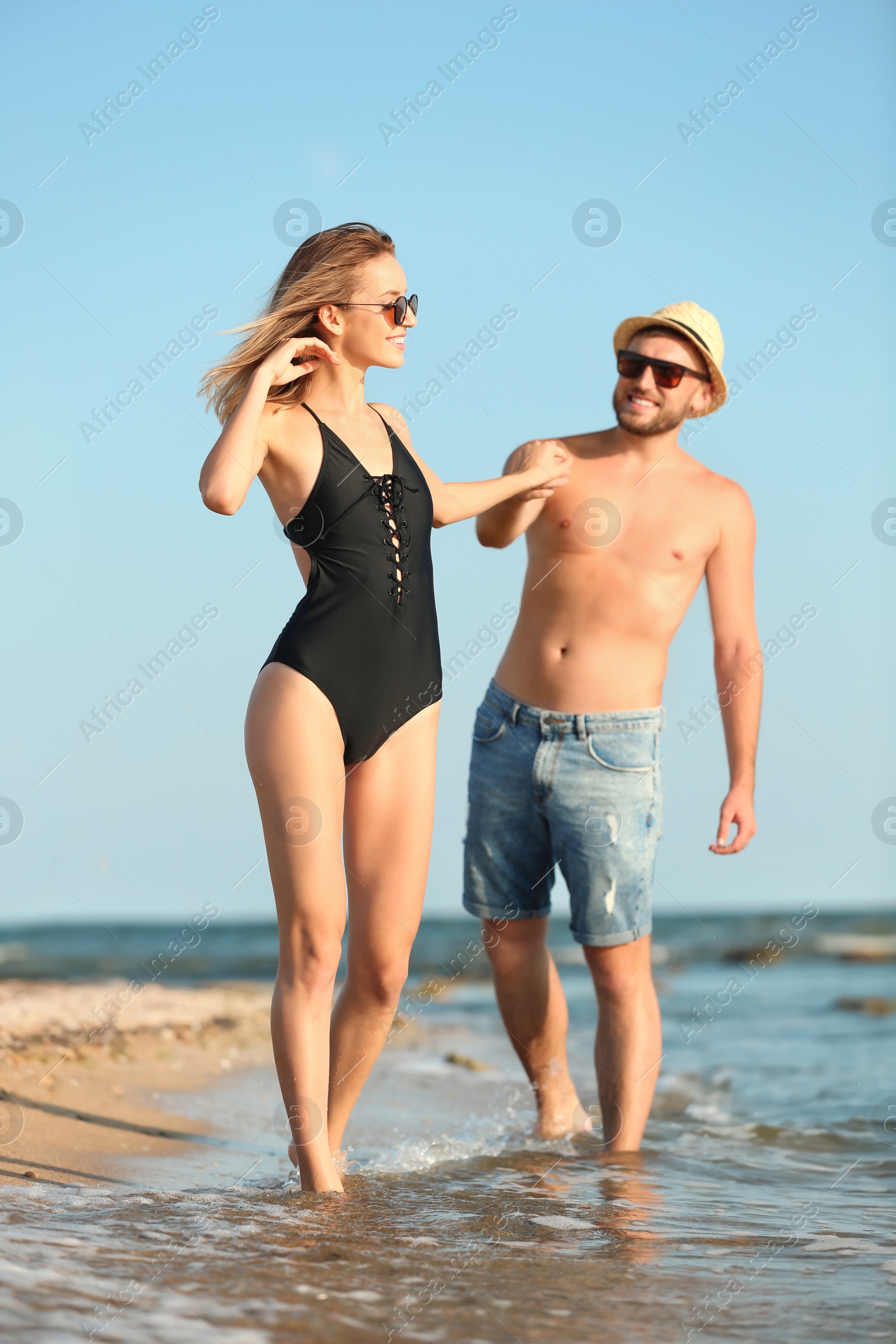 Photo of Young couple spending time together on beach