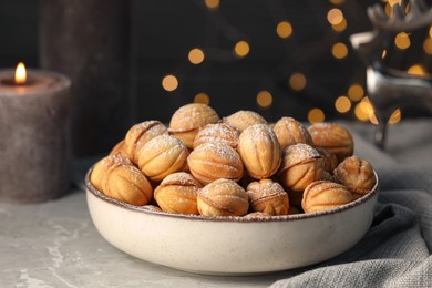 Photo of Bowl of delicious nut shaped cookies on grey table, closeup