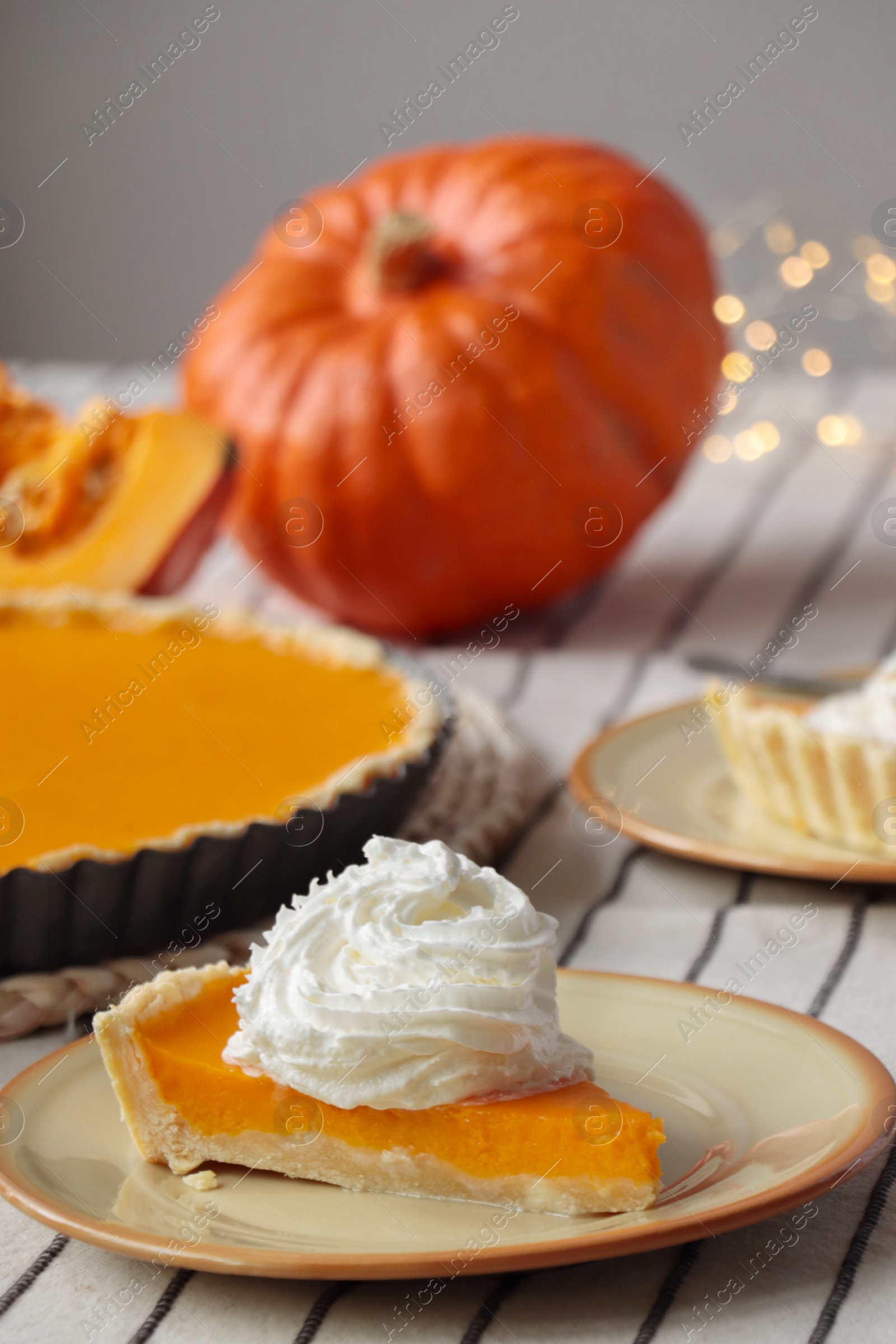 Photo of Piece of fresh homemade pumpkin pie with whipped cream on table