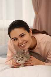 Photo of Young woman with adorable cat at home