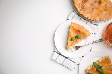 Delicious pie with meat and basil on white table, flat lay. Space for text