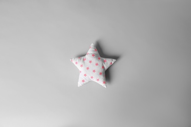 Photo of Soft pillow in shape of star on light background