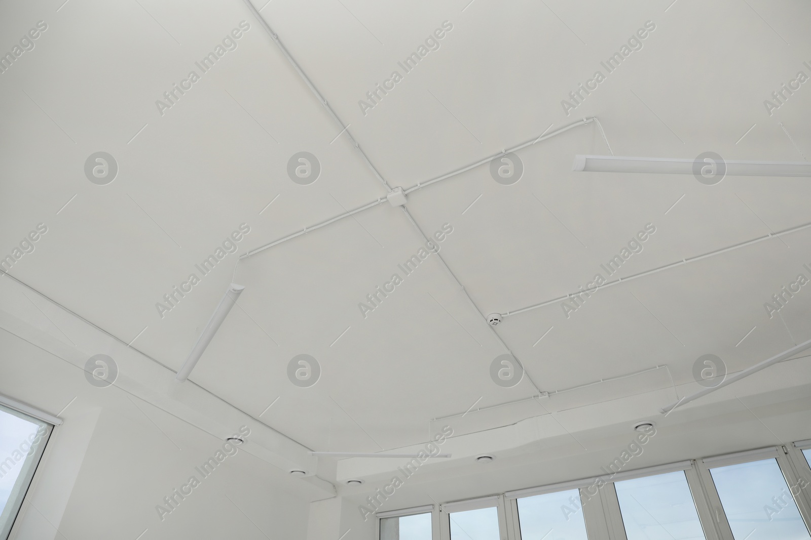 Photo of White ceiling with modern lighting in office