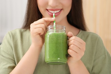 Photo of Young woman drinking delicious smoothie, closeup view