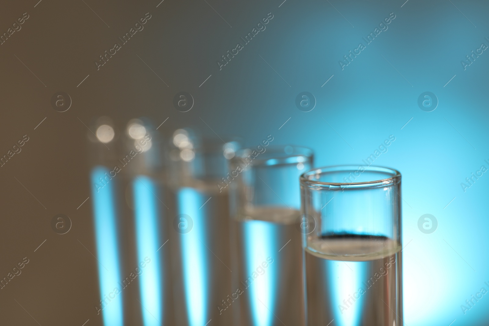 Photo of Many glass test tubes on light background, closeup