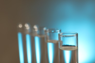 Photo of Many glass test tubes on light background, closeup