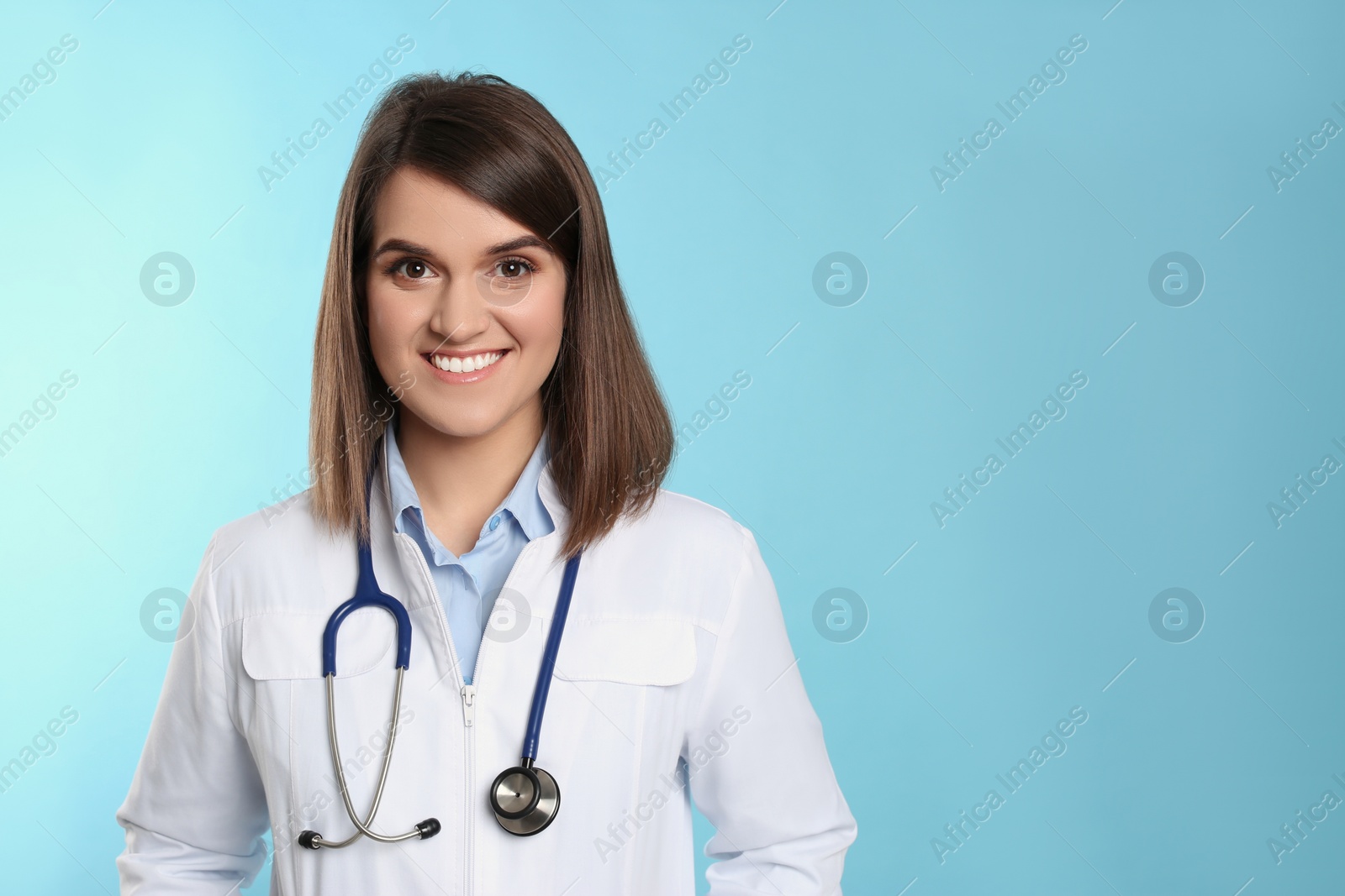 Photo of Pediatrician with stethoscope on light blue background, space for text