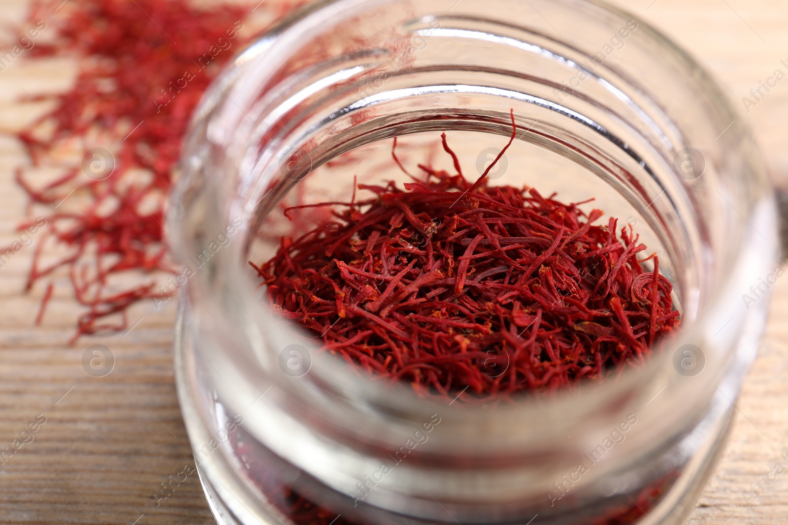 Photo of Aromatic saffron in glass jar on table, closeup