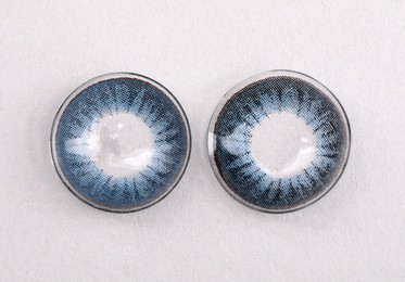 Photo of Two blue contact lenses on white background, top view