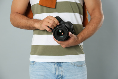 Photo of Professional photographer working on light grey background in studio, closeup