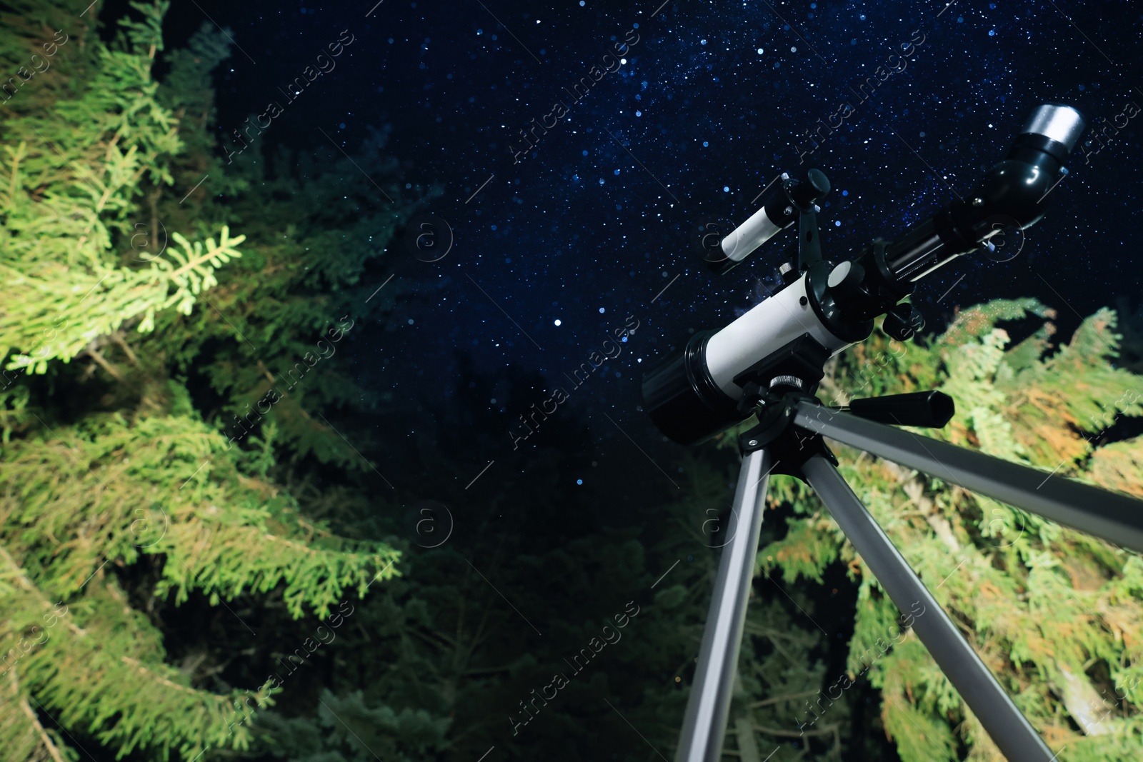 Photo of Modern telescope at night outdoors, low angle view. Learning astronomy