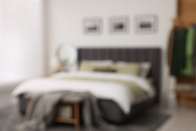 Blurred view of room with comfortable bed