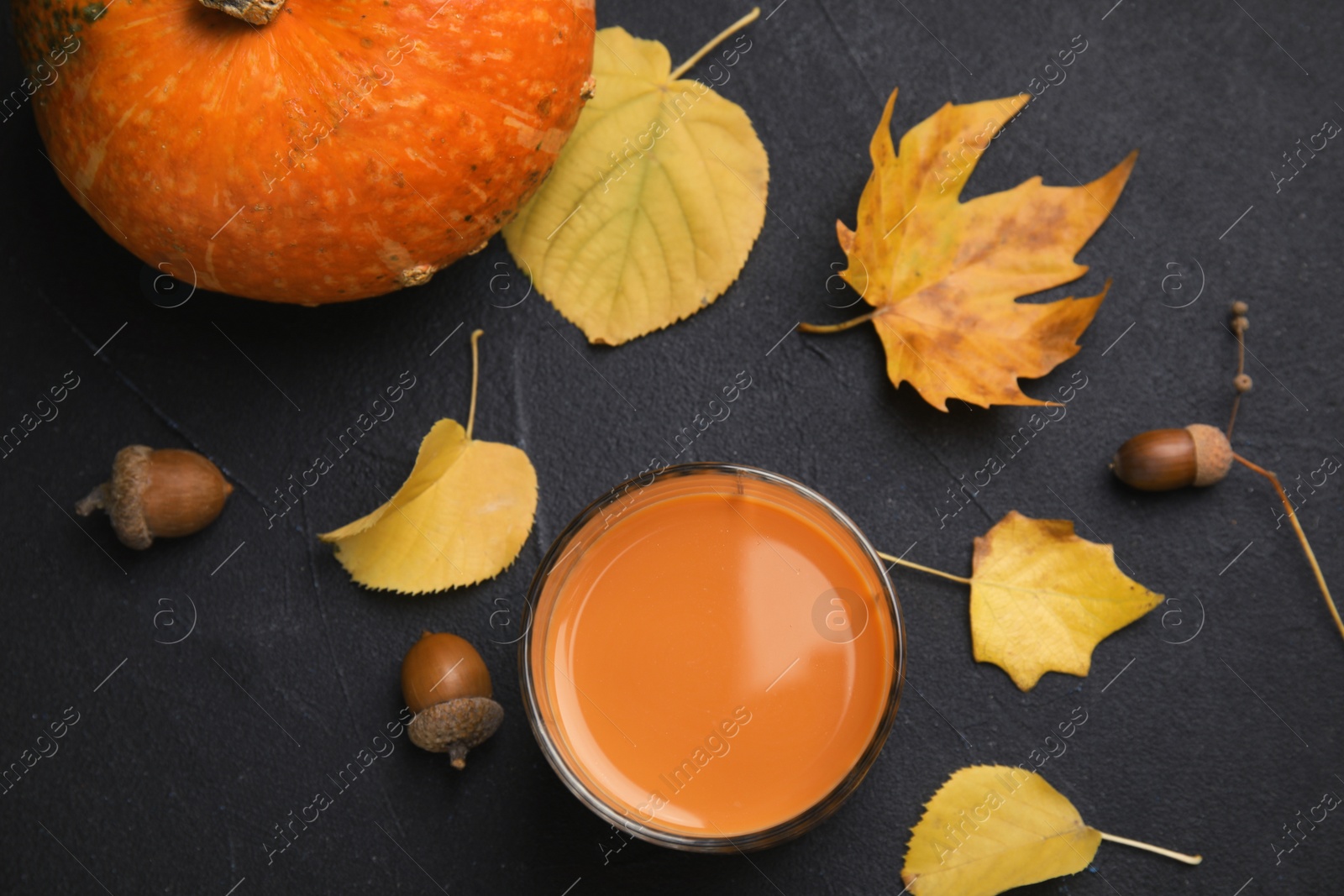 Photo of Flat lay composition with pumpkin spice latte in glass on dark background