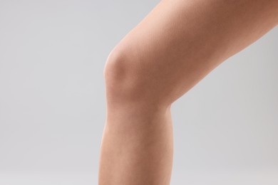 Photo of Woman with slim legs on grey background, closeup