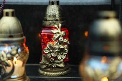 Photo of Grave lights on granite surface at cemetery, closeup